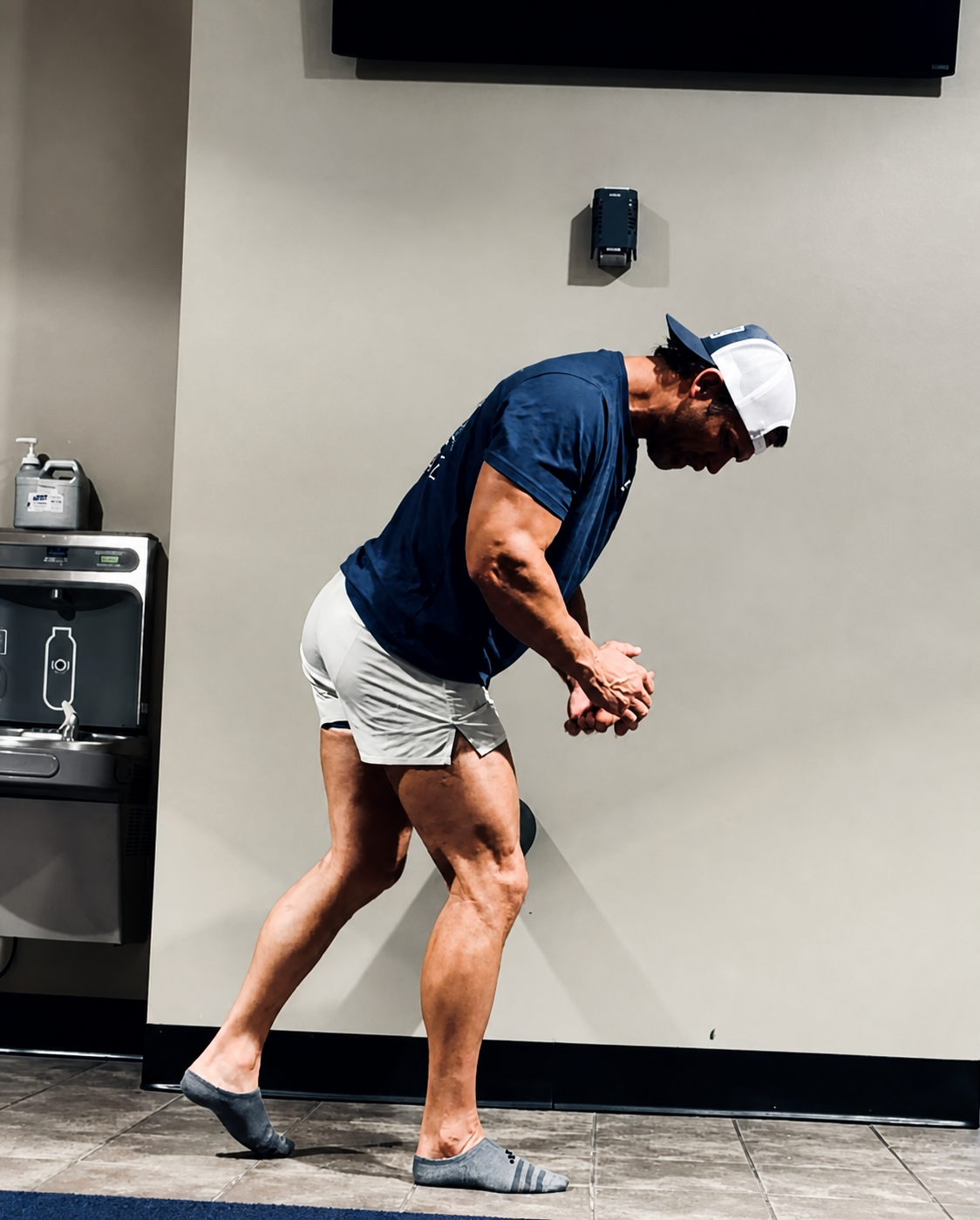 Full-body photograph of Trey demonstrating a strength and mobility movement